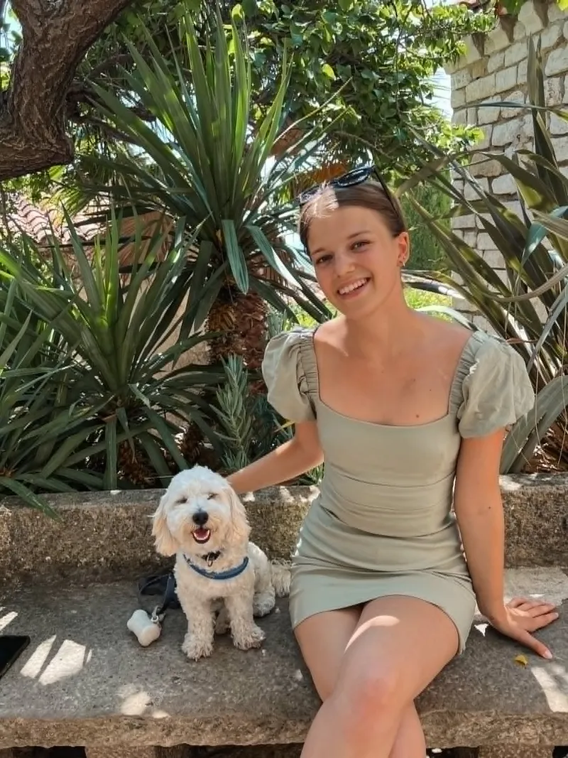Vivi in a green dress with her dog Miro